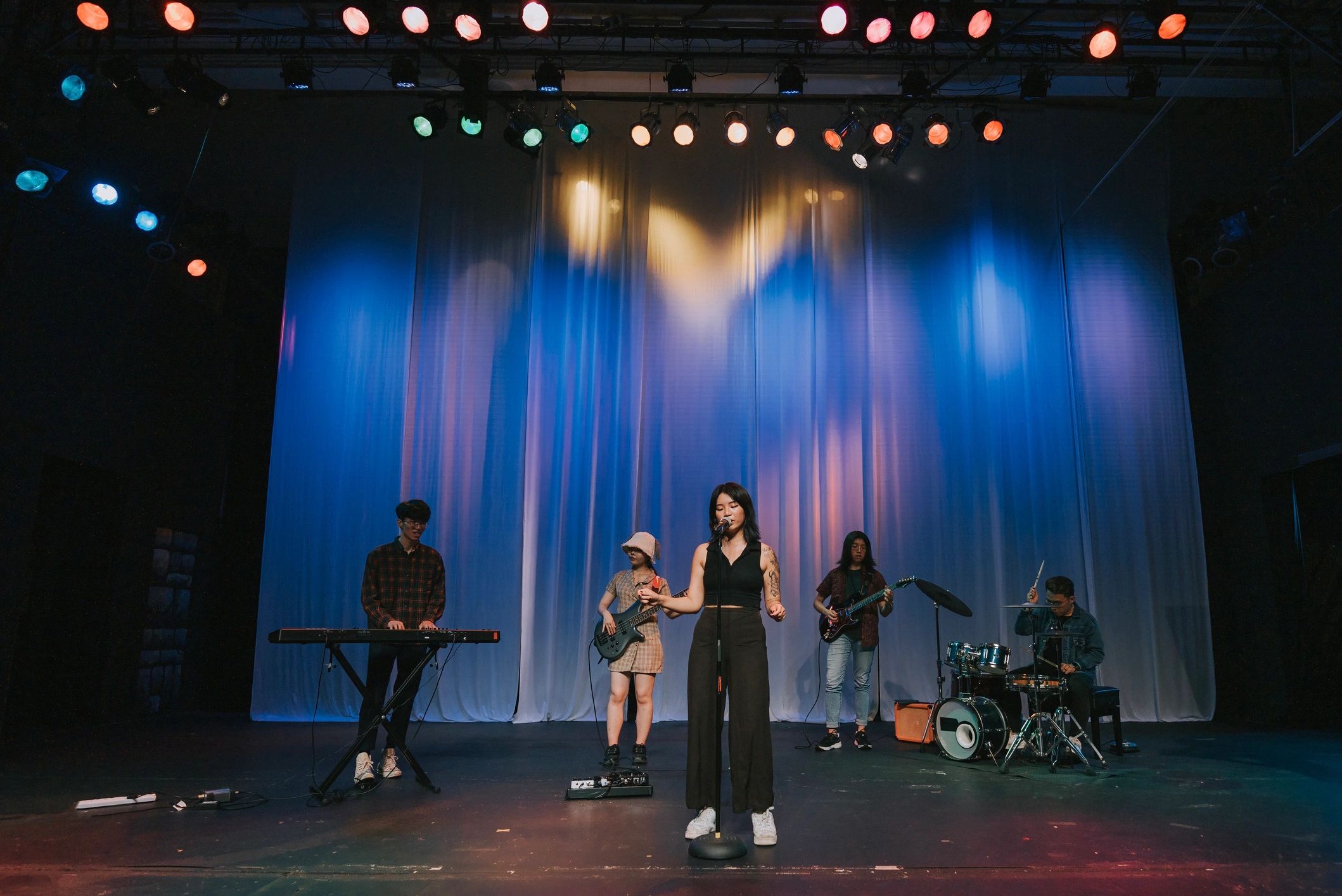 Live stage performance with singer and band under bright lights